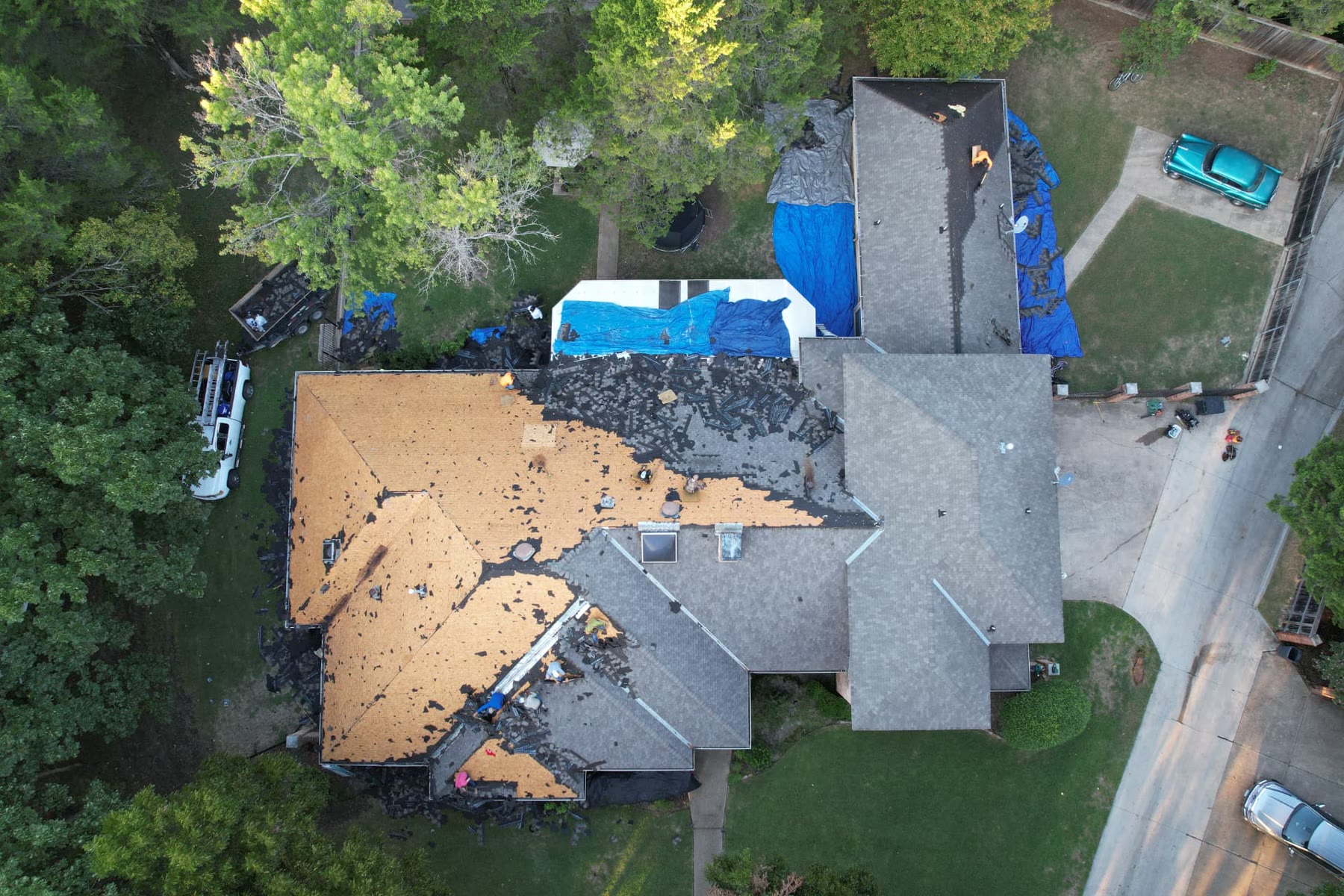 Top-down photo of a roof replacement with exposed decking, removed shingles and new shingles installed